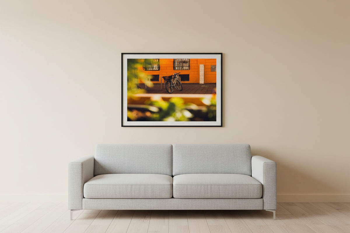 Lifestyle mockup of bicycle wall art print in a modern living room with warm beige wall